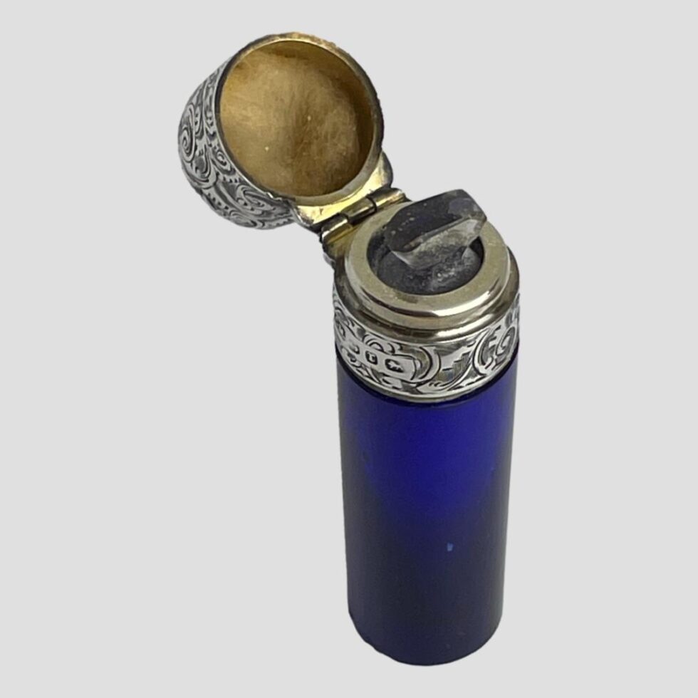 Photo of antique portable scent bottle displayed with the lid open revealing the original glass stopper inside.