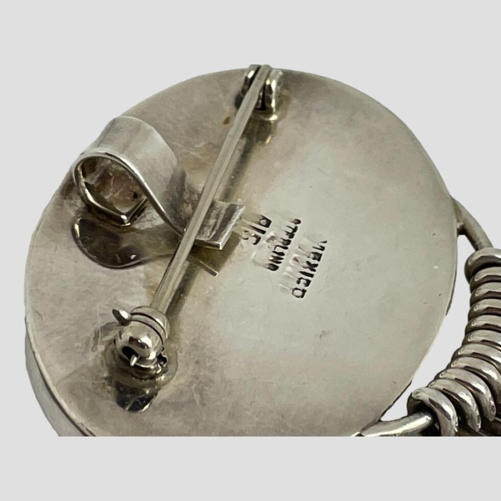 Close up photo of the hallmark on the back of brooch pendant