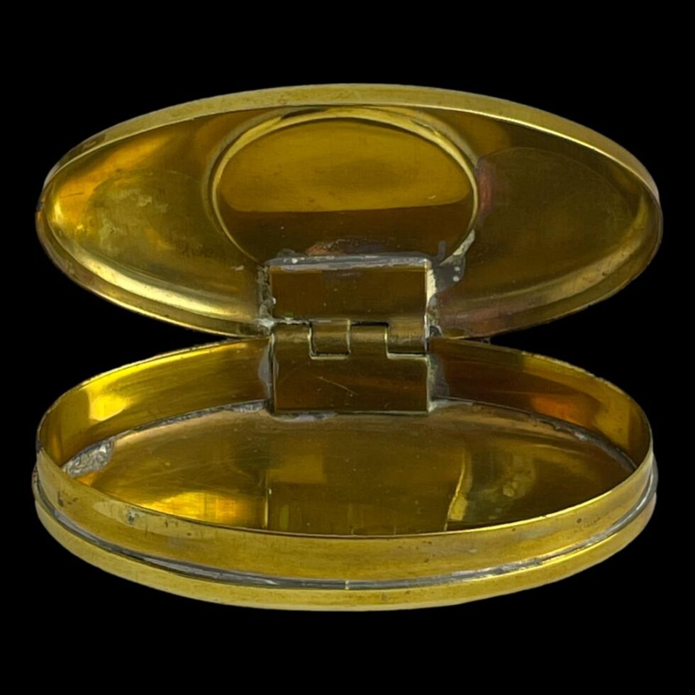 Photo of antique brass snuff/twist box displayed with the lid open showing the very clean interior.