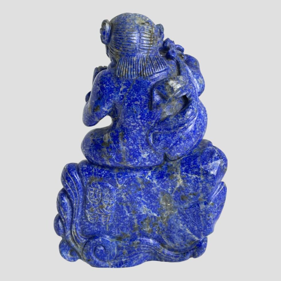 Photo of the back of figurine with continuation from the front. The illegible signature is to the left of the rock.