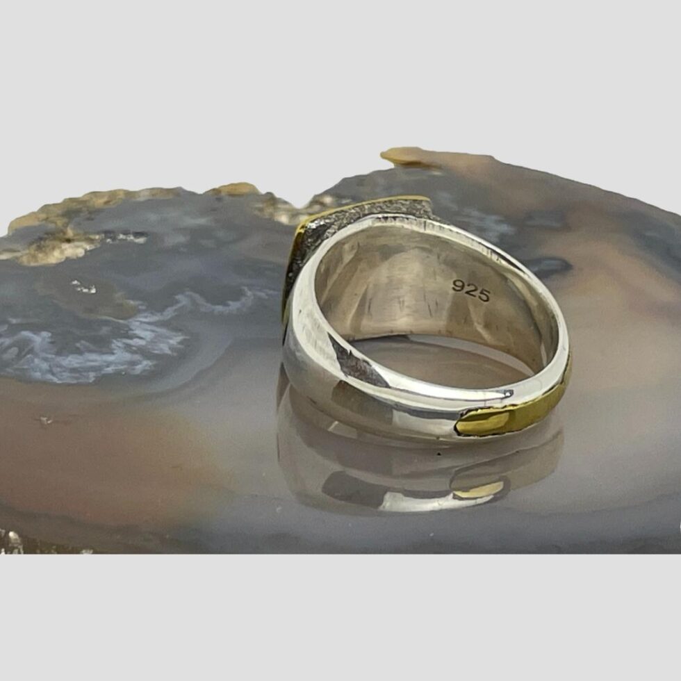 Photo of floral Medieval ring this time with ring front facing top left corner. The 925 hallmark is visible in the inside band and the end of the long gilt metal strip is visible on the back of band.