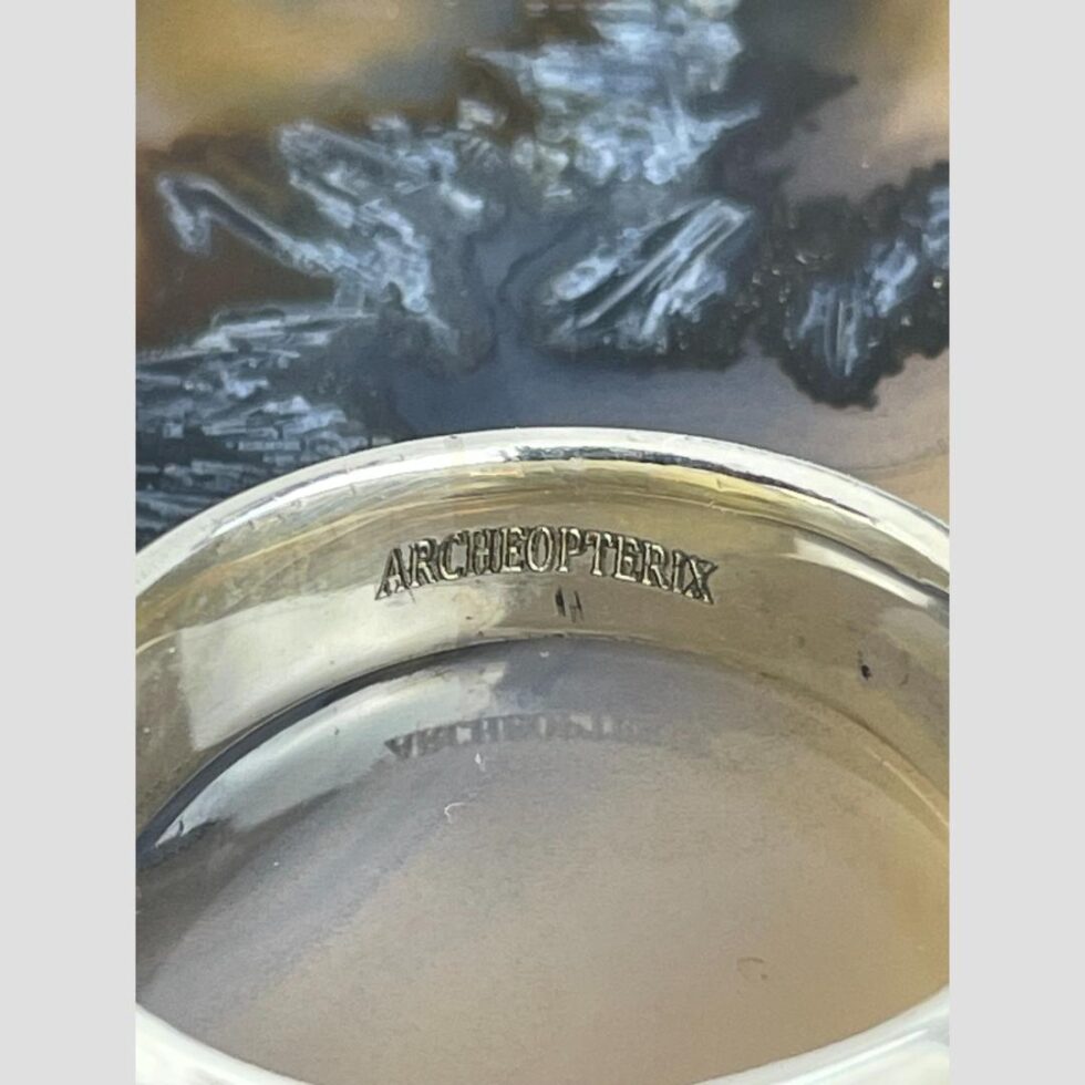 Close up photo of the designers stamp 'Archeoptrix' on the inside band of ring.