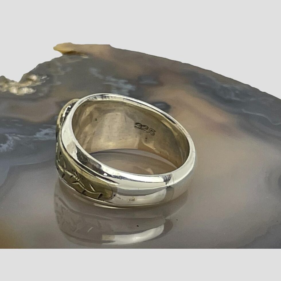 Photo of Medieval fragment ring with the ring front facing to the top left corner. The 925 sterling silver mark is visible to the inside band.