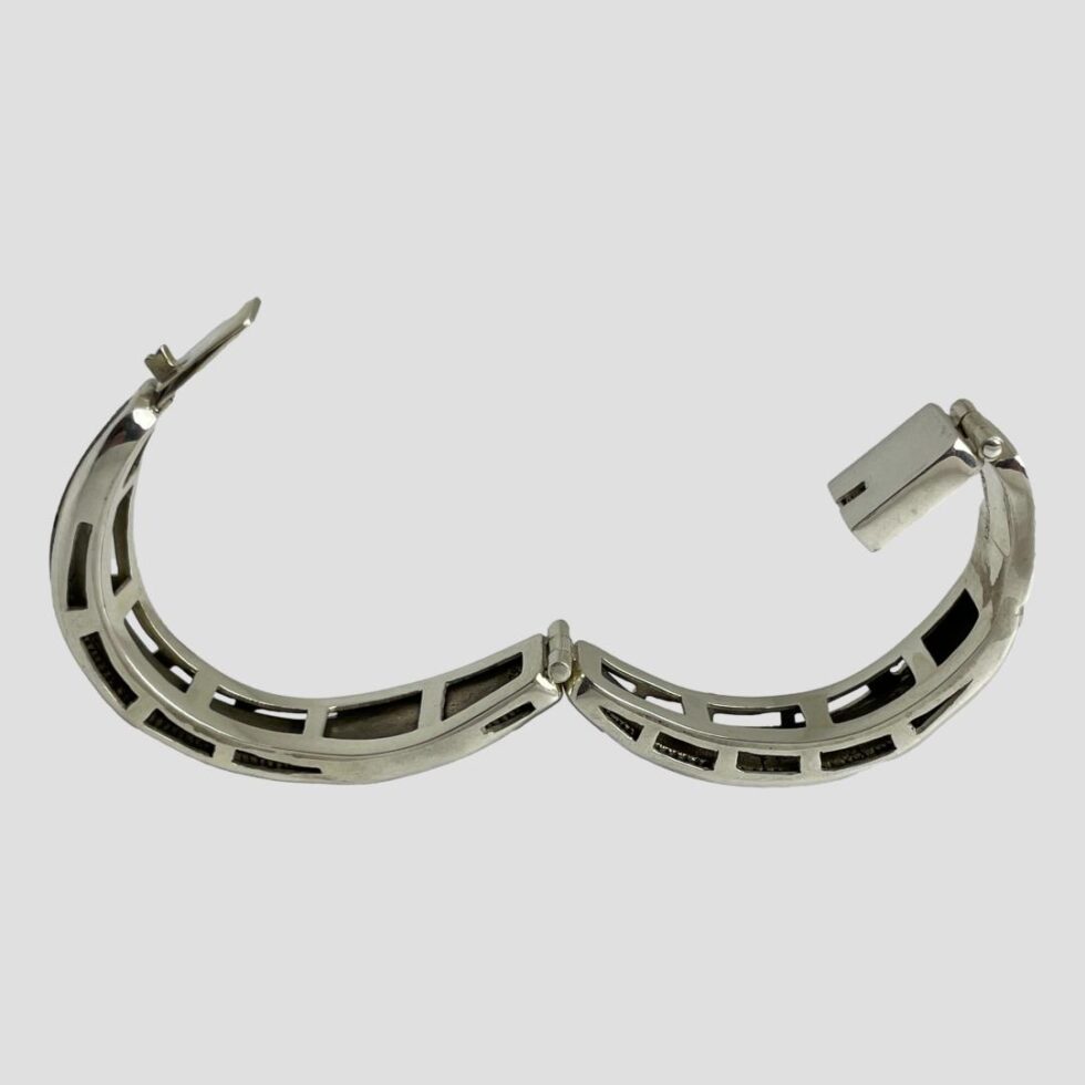 Photo of Viking snake bracelet displayed fully open and standing upright. The ends of the bracelet are to the left and right and the sterling silver framework for the bracelet is clearly on display here. The overall structure of the bracelet is well in keeping with the snake theme.