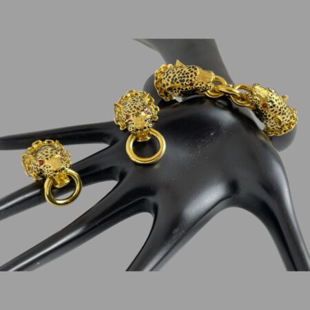 Main photo of leopard door-knocker jewellery set displayed on a black display hand. The bracelet is in the background around the wrist of display stand and the earrings are forward facing and balancing on the hand and finger of the display stand.