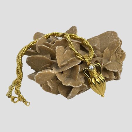 Main photo of amphora pendant/brooch &chain displayed draped over a rock of natural desert rose. The amphora is on the right facing forward and the double rope twist chain is laid over the top of the sand rock with the undone clasp on the left.
