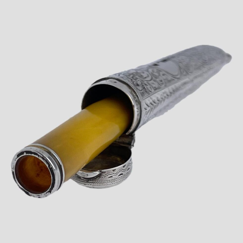 Photo of antique silver cheroot case with the cheroot holder half sticking out.