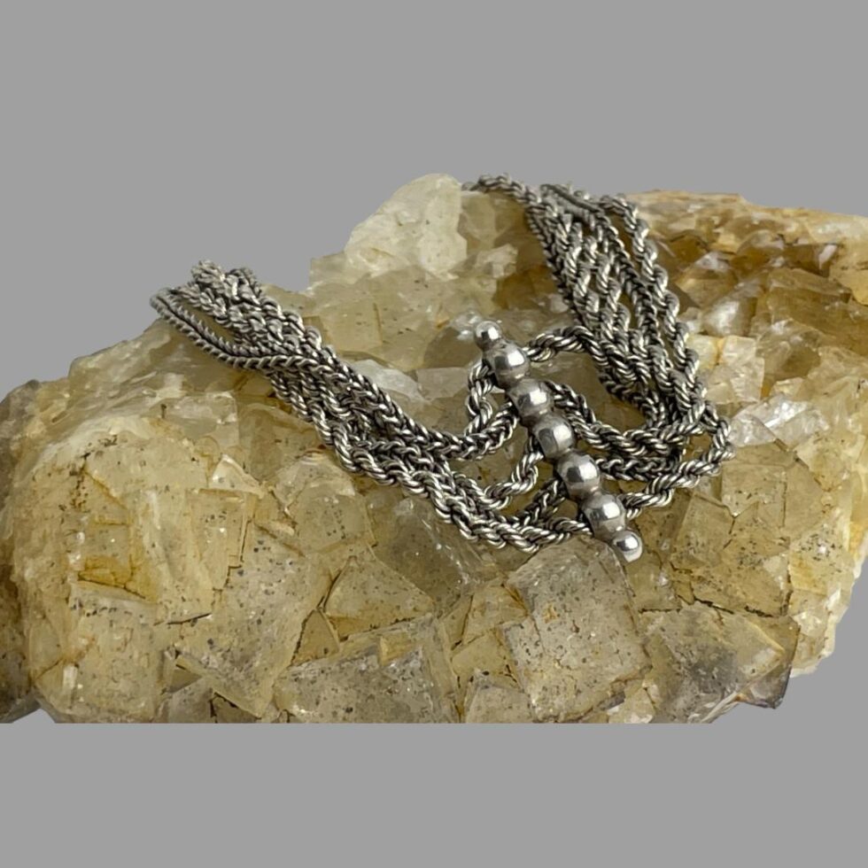 Photo of the opposite side of the clasp end of Albertina chain bracelet showing a central bar separator of 7 silver beads with the 5 larger beads having a silver chain going through to keep them separate. a small silver bead is at either end of the bar separator.