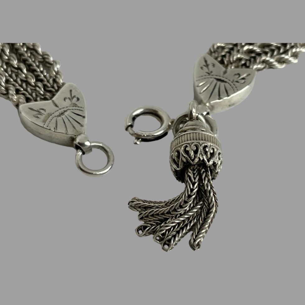 Close up photo of the heart, clasp and tassel area with the clasp shown undone.