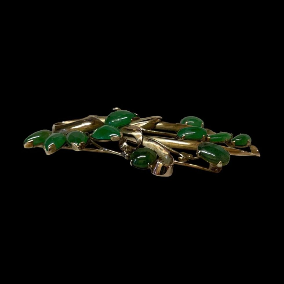 Photo of the jade spray brooch displayed from a side view to show the depth of the brooch.
