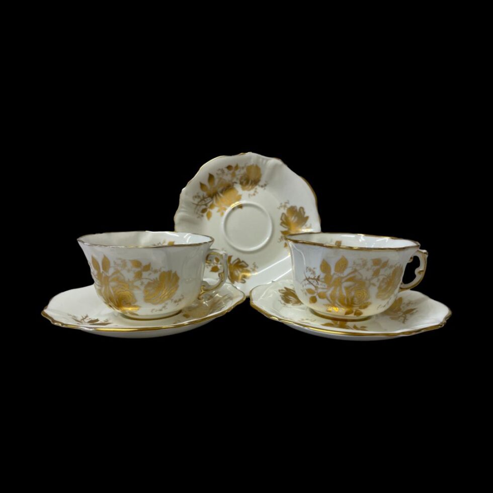 Photo of the 2 cups and saucers displayed side by side with handles to the right. The spare saucer is propped up behind the 2 cups and saucers.