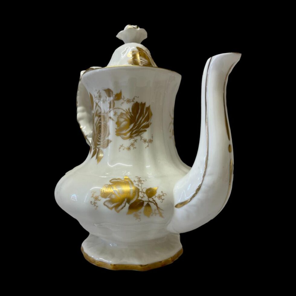 Photo of the tea/coffee pot only against a black background. The spout base is to the bottom right foreground with the top of spout pointed to top right corner.