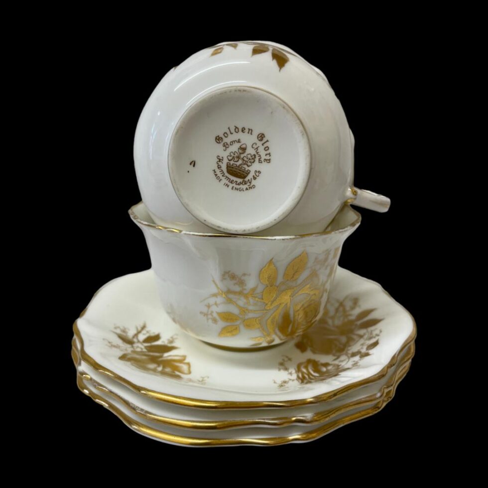 Photo of the cups and saucers this time the 3 saucers are stacked on top of each other and the cups are on top with the cup at very top showing its base with the makers stamp and pattern design visible.