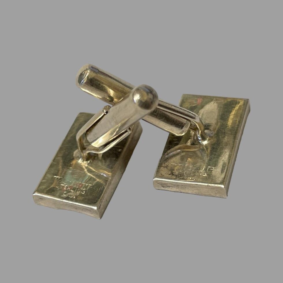 Photo of both cufflinks displayed face down with the bar toggle on both shown open or straight.
