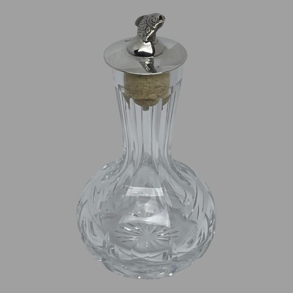 Photo of bitters bottle this time with the salmon dasher on the top facing towards the bottom right. The pourer which is the salmons open mouth is visible here.