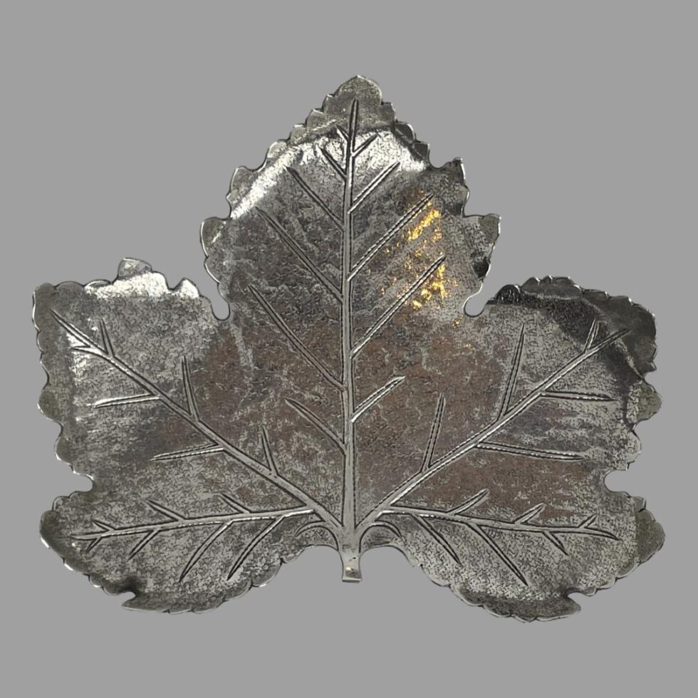 Main photo of silver leaf pin dish looking straight down at the full form from above. The leaf, a maple, is very realistic with the overall shape and the veins within the leaf. The tips of the leaf ends curl a little inward creating a natural leaf lip for the dish. Very high quality workmanship.