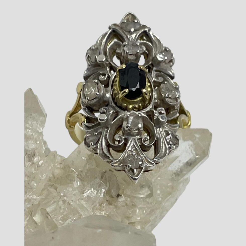 Photo of the Edwardian sapphire diamonds ring displayed on natural quartz crystal and seen in close up from the bottom up. The ring front is facing centre top