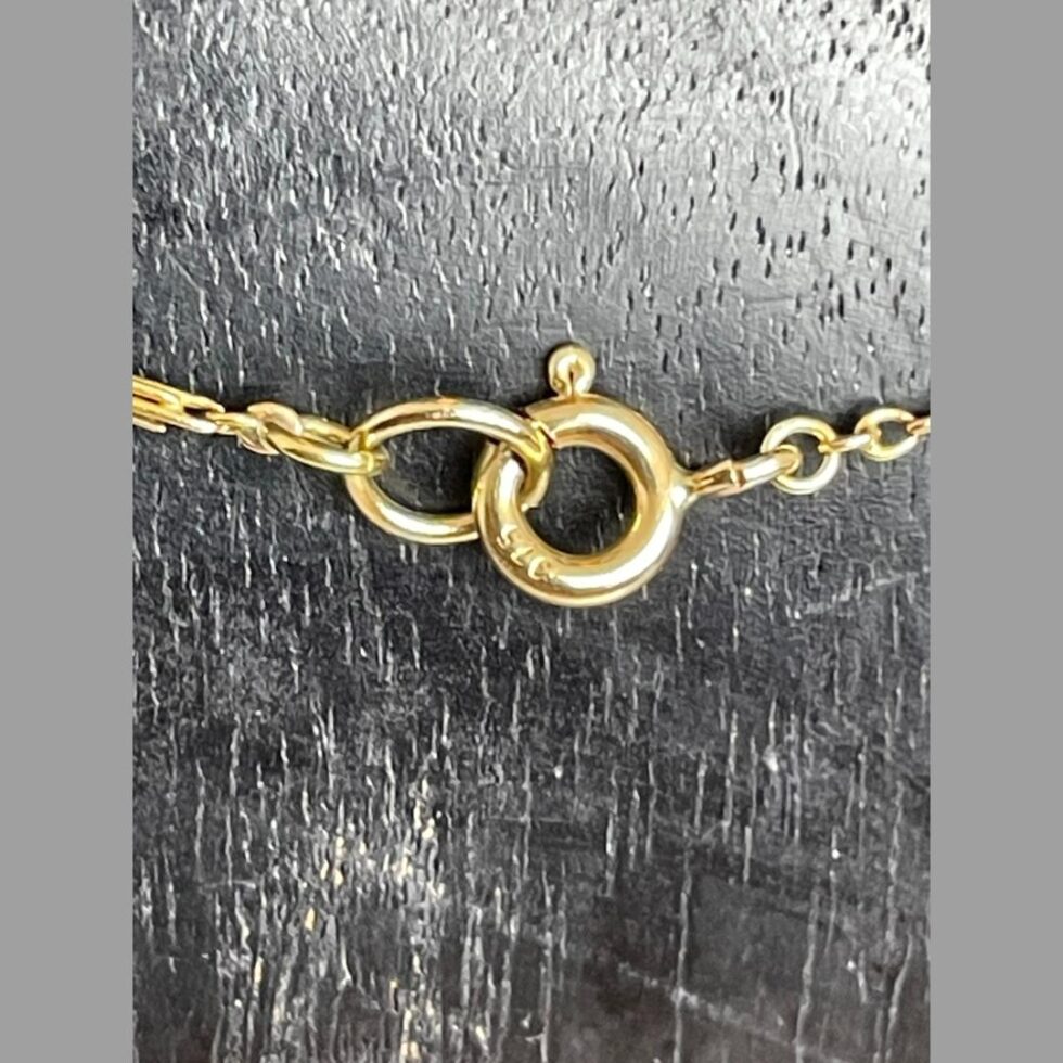 Close up photo of the hallmark on the clasp of antique gold &sapphire necklace.