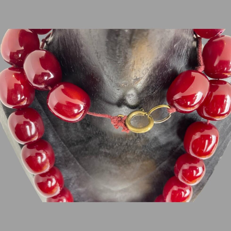 Close up photo of the clasp area of the necklace still hanging on the wooden display stand. We are looking diagonally downward.