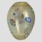 Main photo of 1970s Murano glass vase seen from an eye level showing the side with the original sticker label on. The vase has an almost egg like shape with the pointier end of 'the egg' at the base. The murrine areas are scattered around the vase and all are different in size and colour. The main body of the vase is a slightly milky glass with gold dust flecks inside.