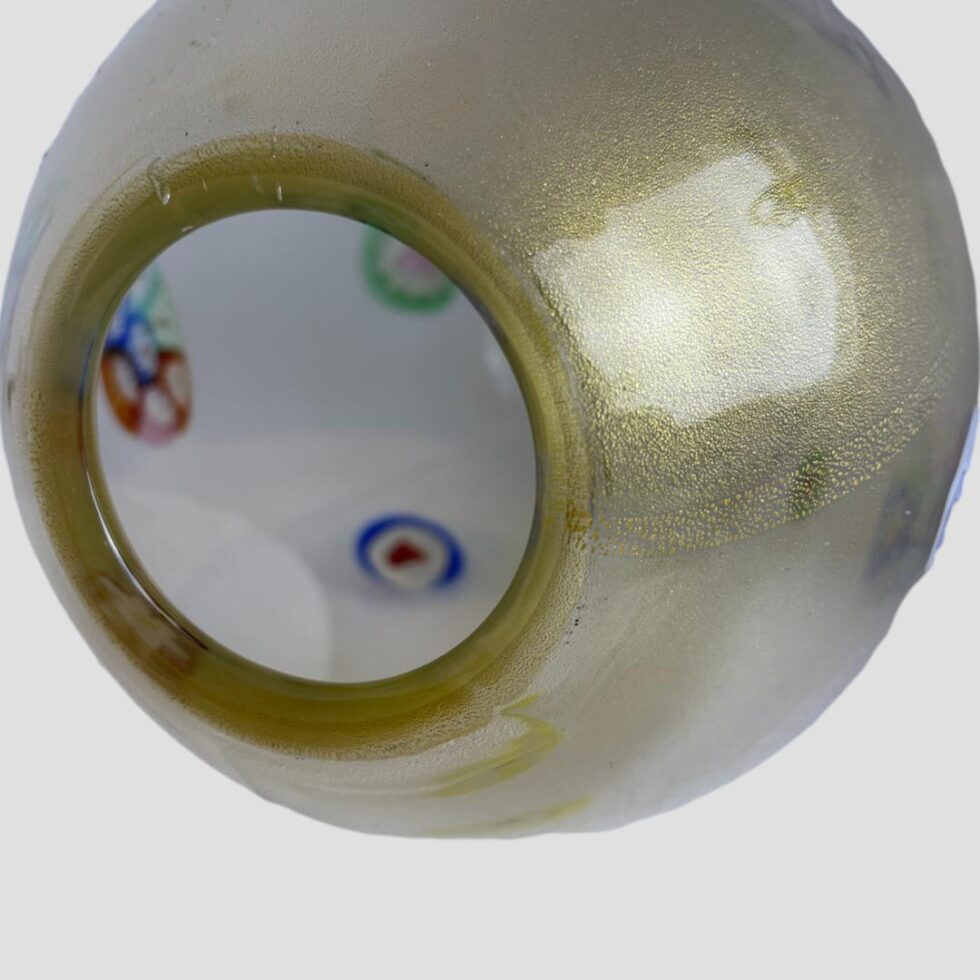 A close up photo around the mouth of the 1970s Murano glass vase showing the glittery gold flecks inside the glass under the studio light.