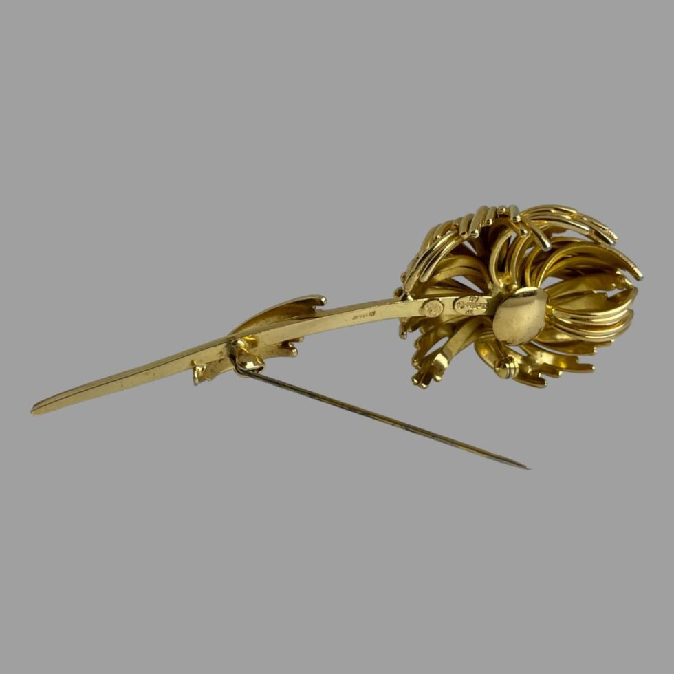 Photo of the Dior brooch still on its side but this time displayed from the back. The pin is still propping up the brooch.
