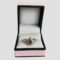 Main photo of tourmaline & sapphire ring displayed inside its ring box which has a baby pink colour exterior with black beading. The ring is forward facing with the pointed end at the top.
