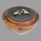 Main photo of gold blue gemstone ring displayed inside a wooden ring display stand with black interior. The ring front is forward facing and slightly upward showing the 2 gemstones. The pear or tear drop cut stones are set top to tail diagonally to the left and right of the band and held at the middle with a short gold divider. The ring shoulders are wider than the rest of the ring band to accommodate the diagonally set stones. The shoulders have 2 parts ; a shorter one with the wider end of the stone set in and a longer almost water droplet like extended piece which runs along the side of one pear shaped stone with the pointed ends at the centre. The ring appears like it has a split band but is solidly set as a whole ring.