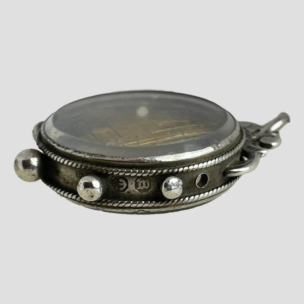 Photo of Victorian Westminster Abbey souvenir fob laid flat with the assay office and date stamp on display in between 2 of the silver balls. The P of the makers mark is just visible to the left of the hallmark on other side of the ball.