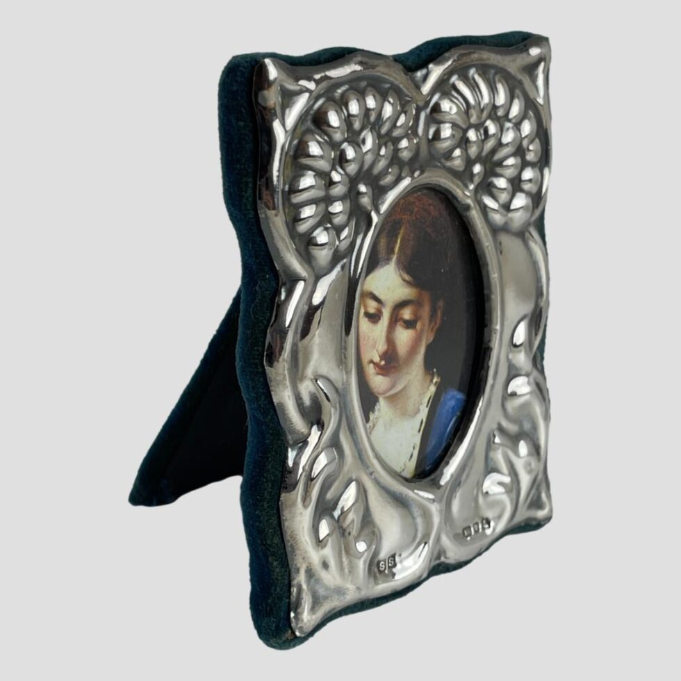 Photo of small silver fronted photo frame this time seen from a slight side angle with the frame front facing towards the bottom right corner.