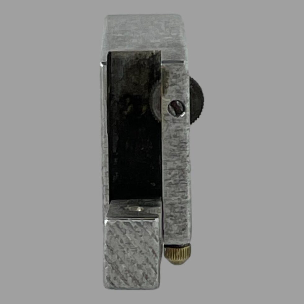 Photo of the trench art lighter with lift arm open and looking straight down inside. There is not much to see as it just shows as a black hole. The tip of the lift arm is to the centre bottom of photo.