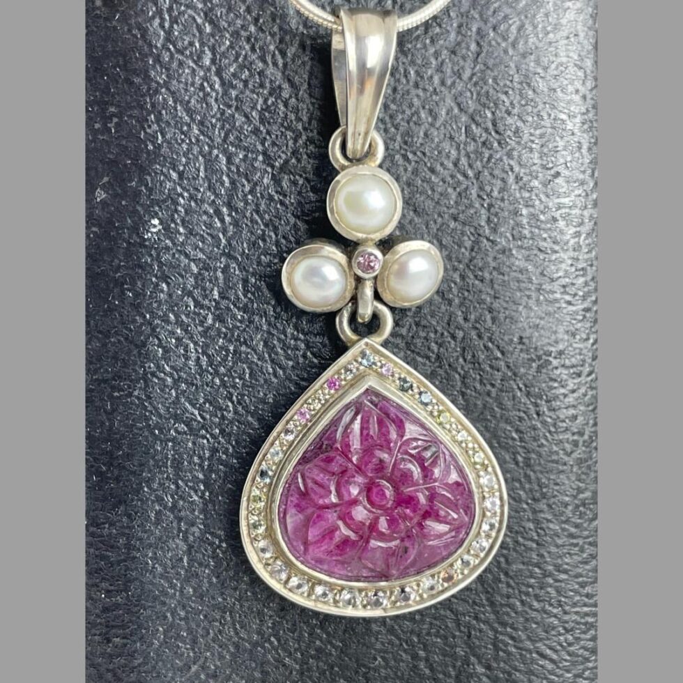 Close up photo of the stunning pendant only seen forward facing and still hanging on the jewellery box.