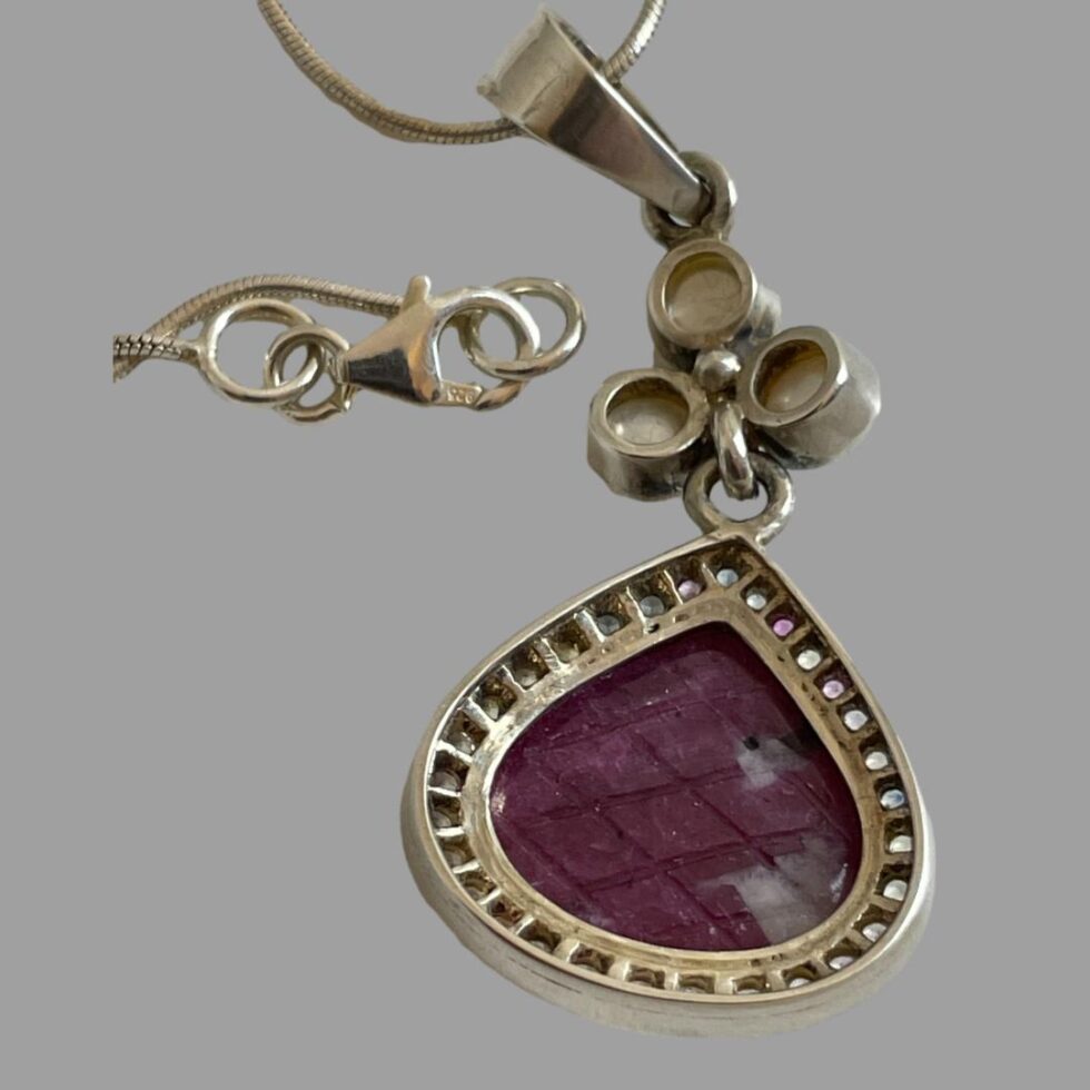 Photo of the back of the pendant showing the setting for the stones and the 925 hallmark on the chain clasp.