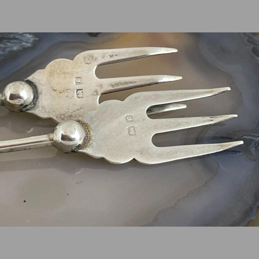Close up photo of the short hallmark on the flat of the fork prongs showing the lion passant mark and date letter g.
