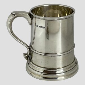 Main photo of silver half pint tankard displayed with the handle on the left and the full hallmark visible on the top right of handle. The tankard is slightly flared at the base making it a sturdy holder of your favourite beer, ale, stout or cider even. The tankard is in very good condition with no damage - almost like it has never been used. Lovely gift item to someone who'll appreciate quality or, as a gift to yourself!