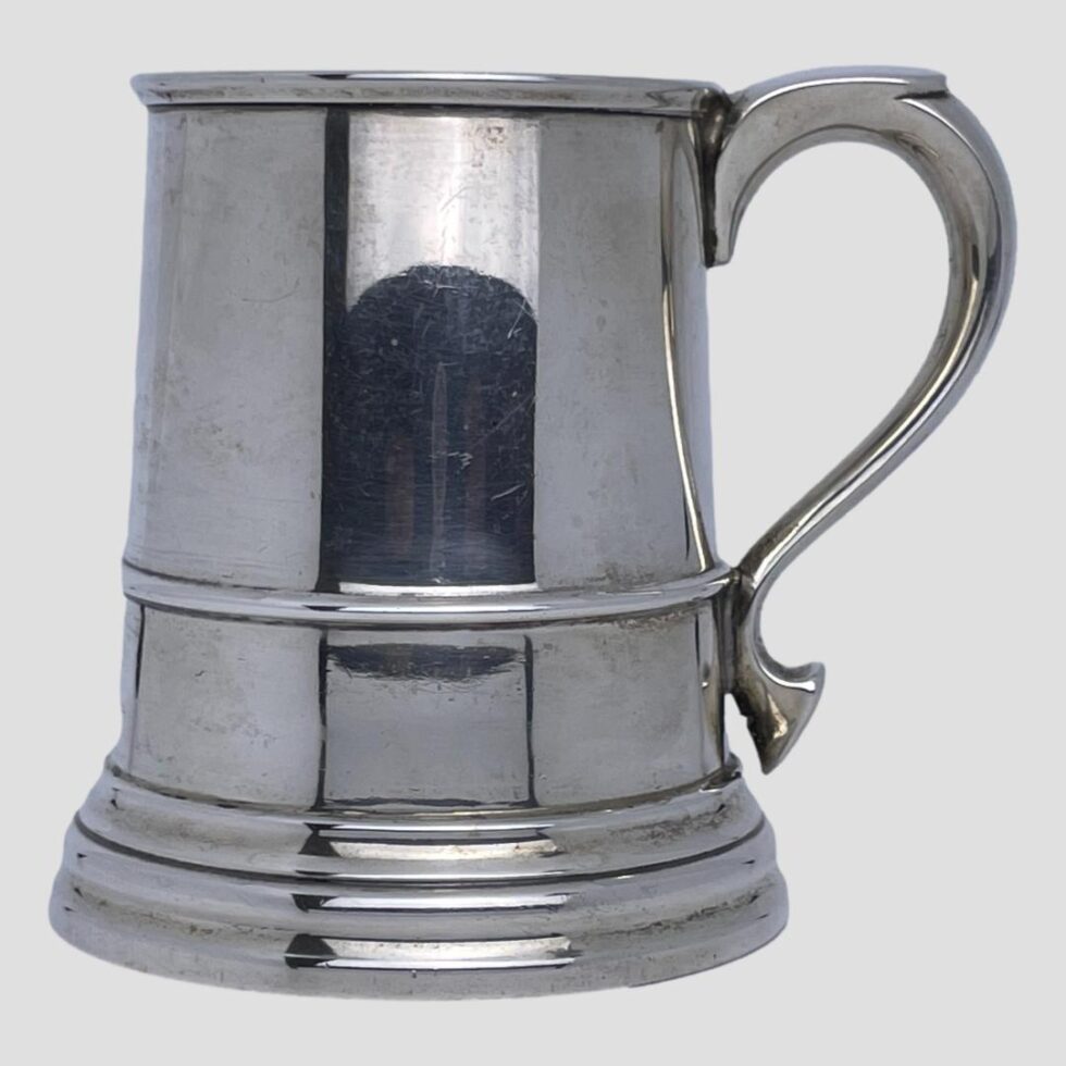 Photo of the silver half pint tankard seen from an eye level with the handle on the right.