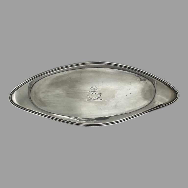 Main photo of George III snuffer tray displayed horizontally upright to show the shape of the tray which is an elongated oval with turned up or raised border. It is almost an eye or almond shape. The crest at the centre is visible which is a ribbon with what looks like a hunters horn of a stand (could be an old hearing aid horn!) Not a lot of use for snuffer trays these days but this could be utilised as an stick incense burner stand as it is long enough. Whatever you decide to use it for, it will be a useful and practical (as well as collectable) item of antique silver.