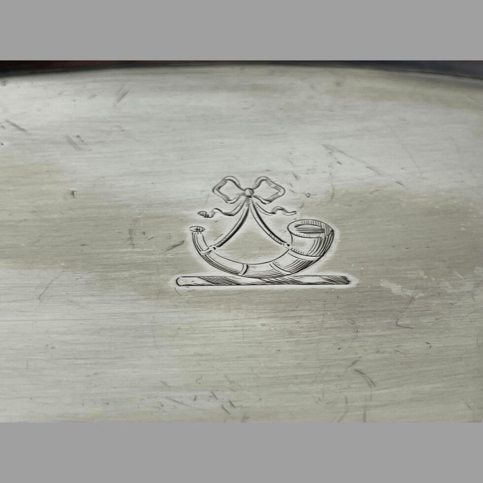 A close up photo of the ribbon and horm cret at the centre of the snuffer tray.