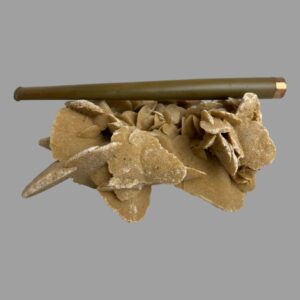 Main photo of gold tipped cigarette holder on top of a rock of natural desert sand rose with the gold tipped rim on the right and the whole length of the holder on display. The tapering from the tip to the mouth end is subtle making it a very elegant looking item fit for Hollywood! A few darker spots and some minor scratches are visible to the Bakelite here.