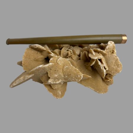 Main photo of gold tipped cigarette holder on top of a rock of natural desert sand rose with the gold tipped rim on the right and the whole length of the holder on display. The tapering from the tip to the mouth end is subtle making it a very elegant looking item fit for Hollywood! A few darker spots and some minor scratches are visible to the Bakelite here.