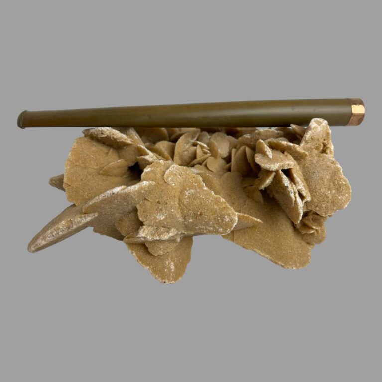 Main photo of gold tipped cigarette holder on top of a rock of natural desert sand rose with the gold tipped rim on the right and the whole length of the holder on display. The tapering from the tip to the mouth end is subtle making it a very elegant looking item fit for Hollywood! A few darker spots and some minor scratches are visible to the Bakelite here.