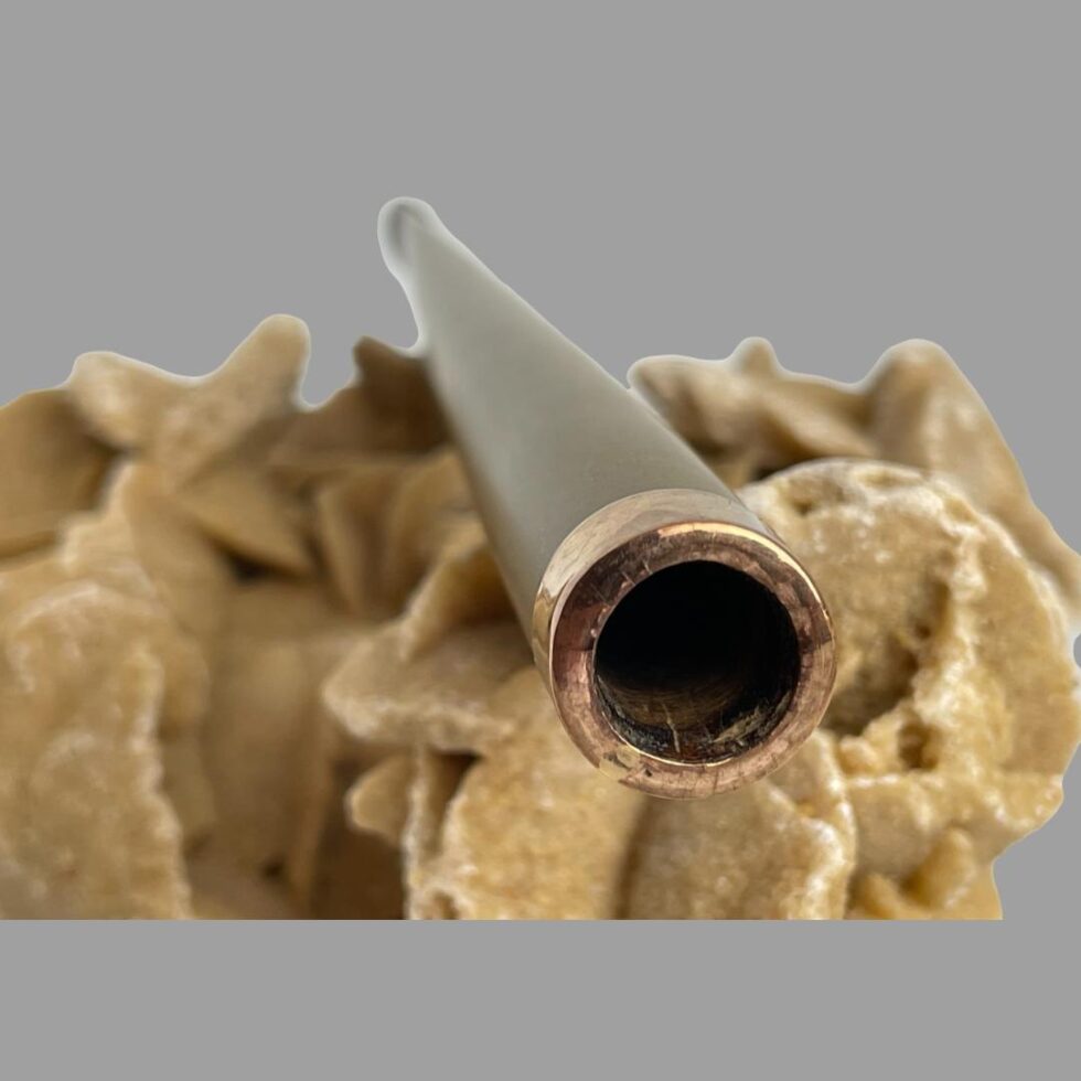 Photo of the gold tipped cigarette holder still displayed on top of the rock of natural desert sand rose and with the tip end in the foreground.