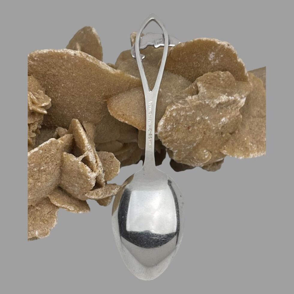 Photo of the back of the silver enamel salmon spoon. The hallmarks, although a little blurry, are just visible to the back of the salmon and spoon handle.