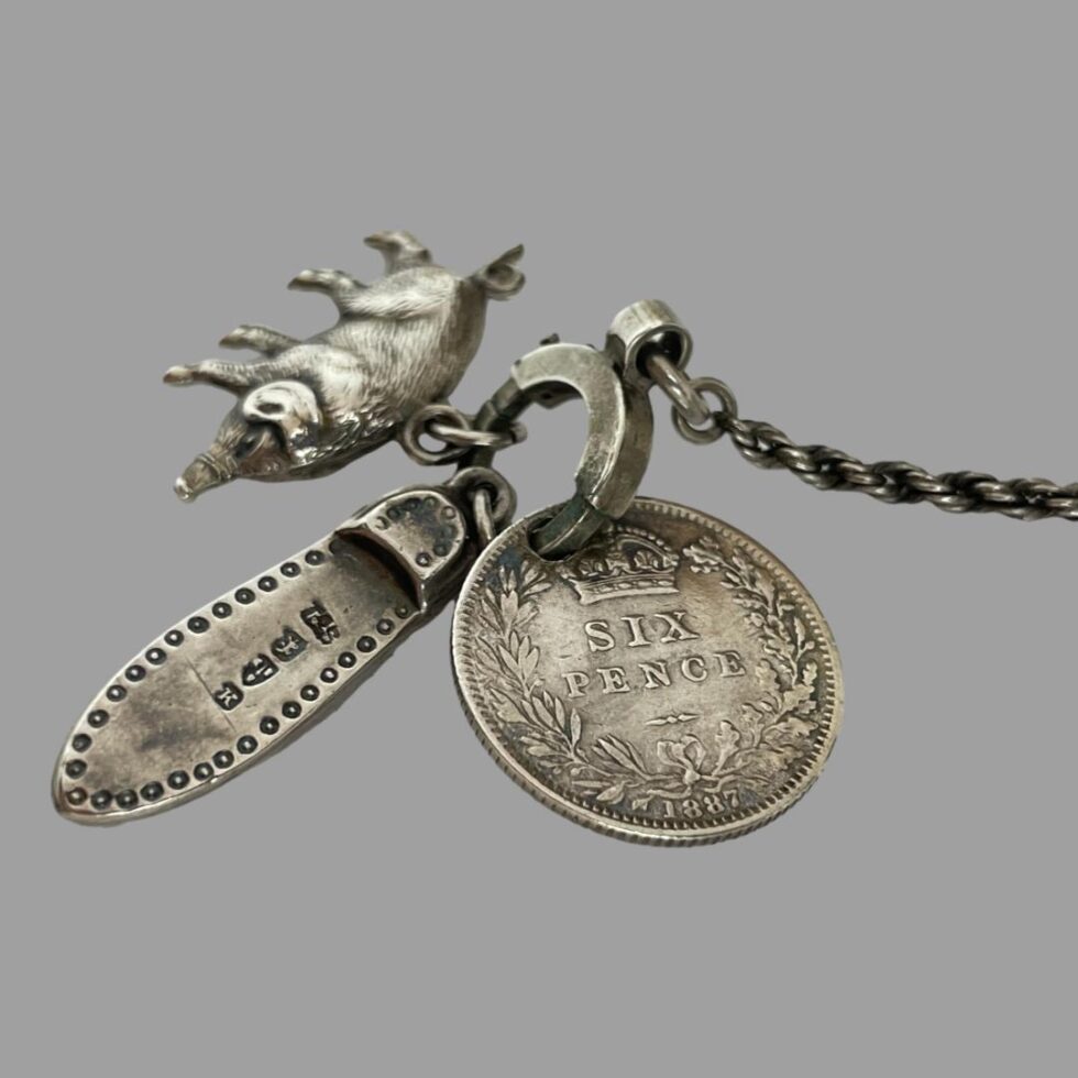 A close up photo now of just the 3 charms. The hallmark is visible on the sole of the fancy shoe. It is strange for no other hallmarks to be present however, this item has been tested for silver.