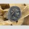 Main photo of Greco-Bactrian one Drachma coin showing the obverse with image of Eucratides I in profile. He is draped and wearing a Boeotian helmet with bulls horn and ear. It is displayed on top of some desert sand rose which can be seen in background. In remarkable condition for an item of this age - just goes to prove, they don't make them like they used to!