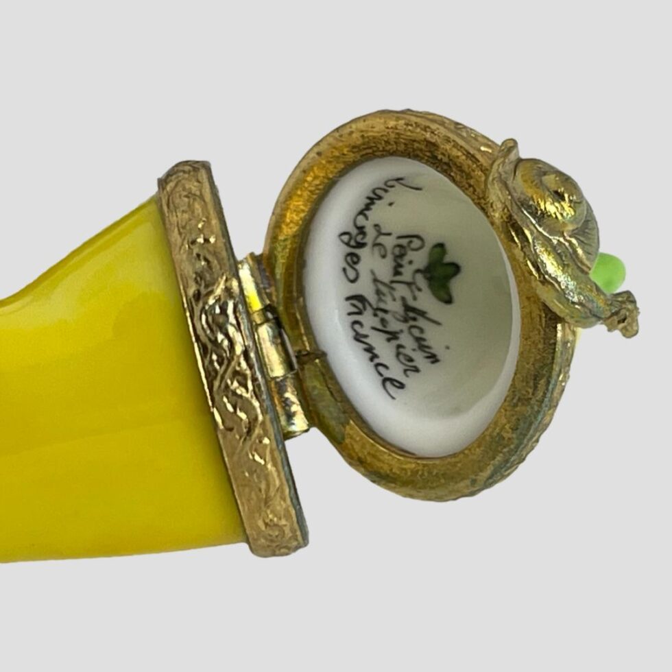 Close up photo of the signature inside the lid of the Limoges yellow chilli box. It reads Peint Main Le Tulipier Limoges France