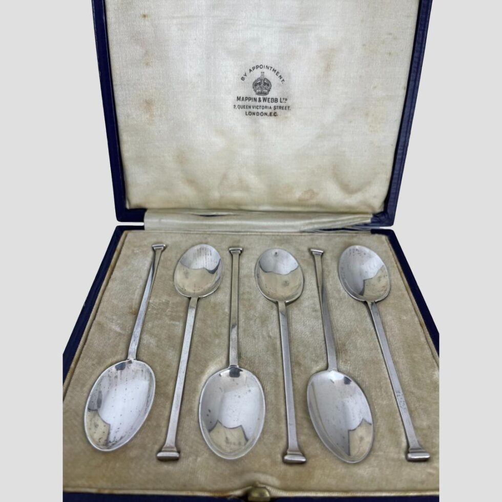 A close up photo of the spoons still inside their fitted case and the Mappin & Webb stamp on the silk above.