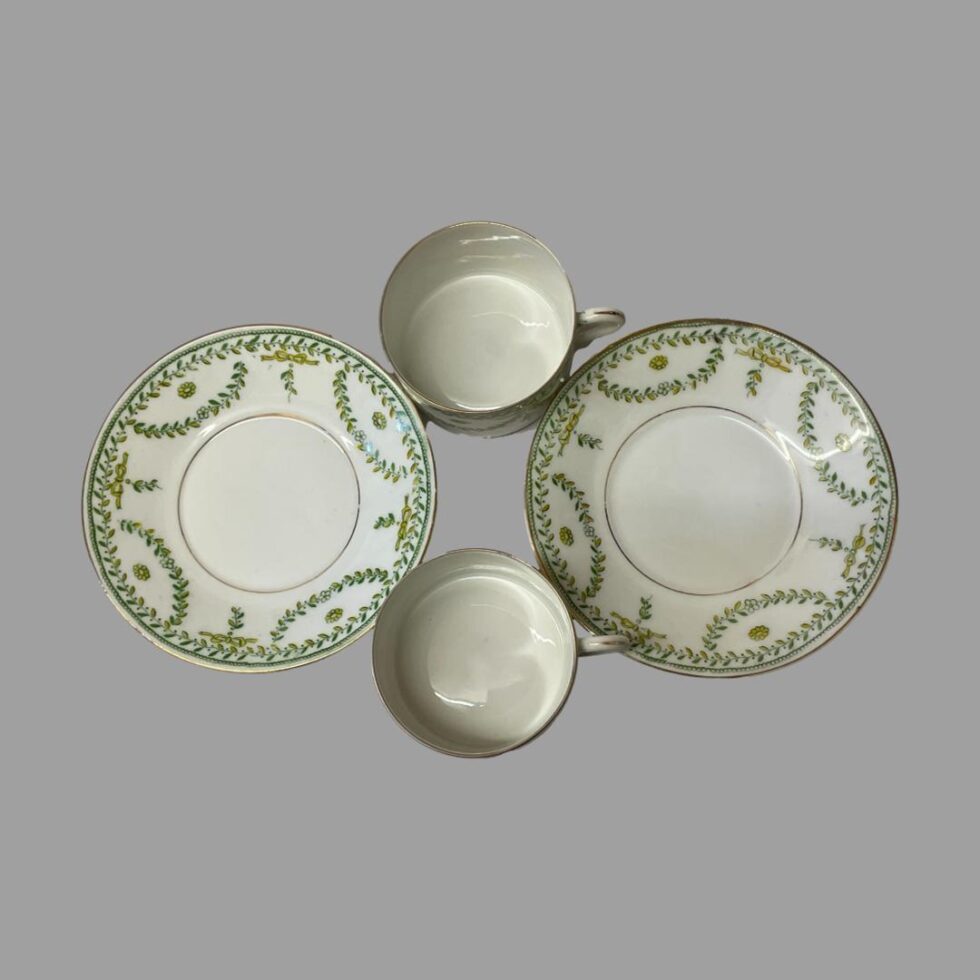 Photo of all 4 pieces of antique Paris cups and saucers all separated and displayed 2 saucers to east and west and cups at north and south. The gilt wear around the inner rim of the saucers is just visible here although hidden when cups are on top.
