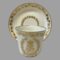 Main photo of antique Sêvres Cup &Saucer with cup placed in front of the saucer which is displayed upright on a stand. The decorated side of cup (opposite end to handle) is shown. The 2 sides do not have any decoration other than the frieze of ivy leaves around the lip.