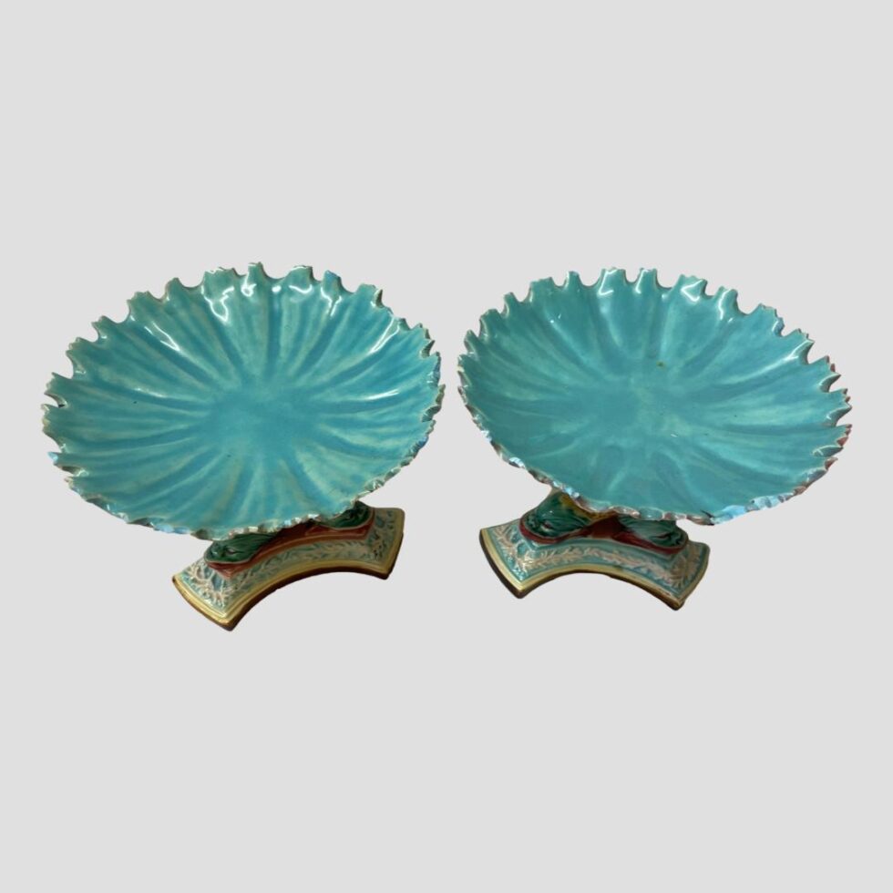 Photo looking down at the scallop edged shell bowls at the top of each. On display, we see a round dish of turquoise with just 2 of the triple footed bases on show. The scallop edged bowls look a little like giant lily pads.